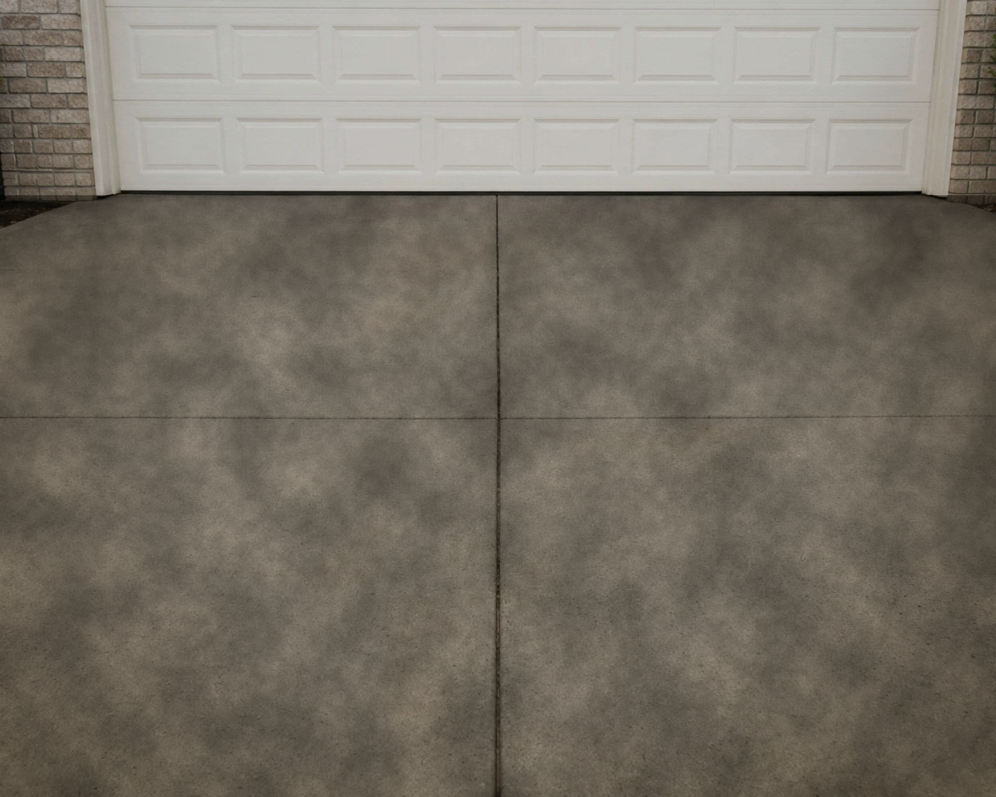 The same driveway before cleaning, stained dark with grime