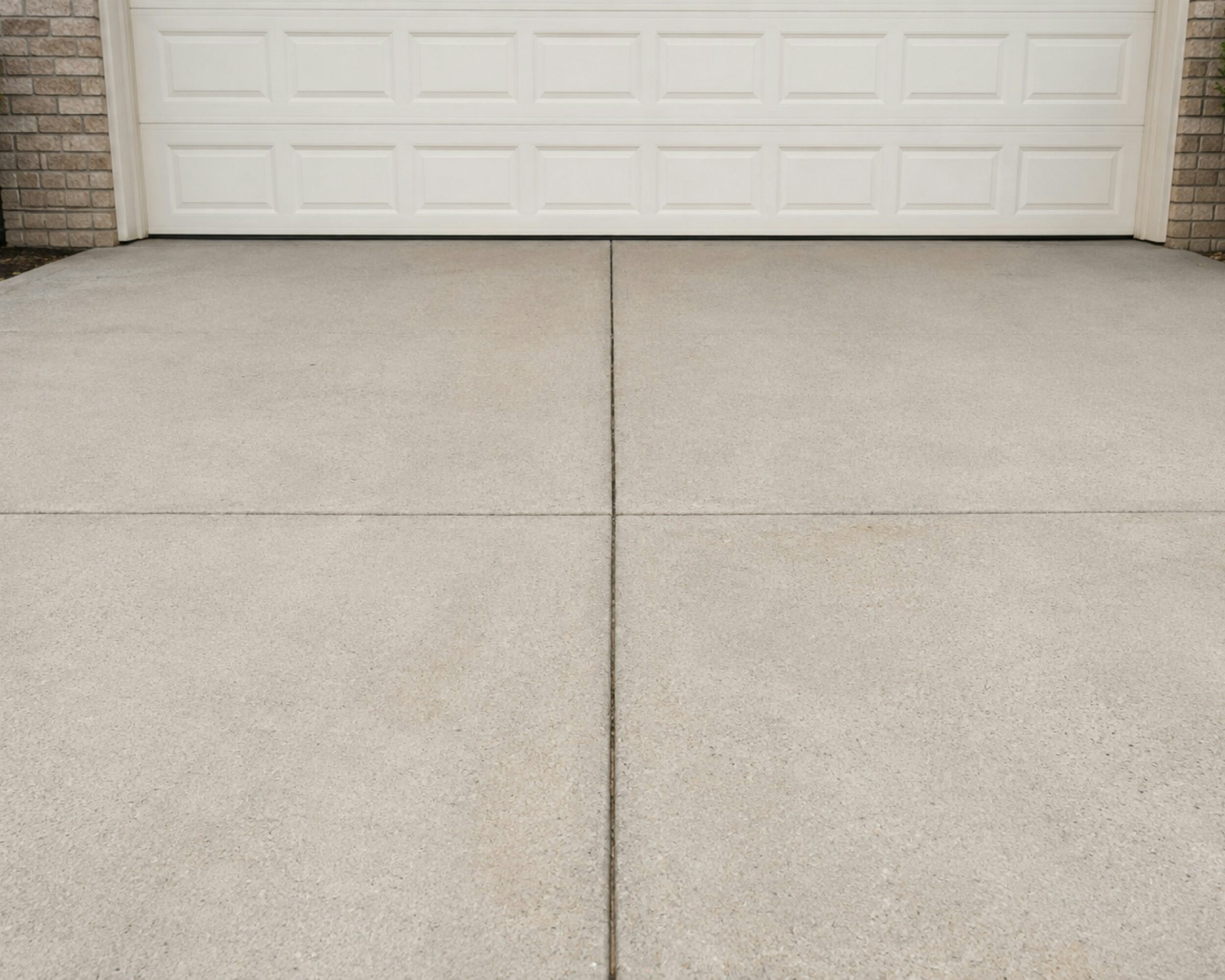 A concrete driveway after power washing, clean and even in tone