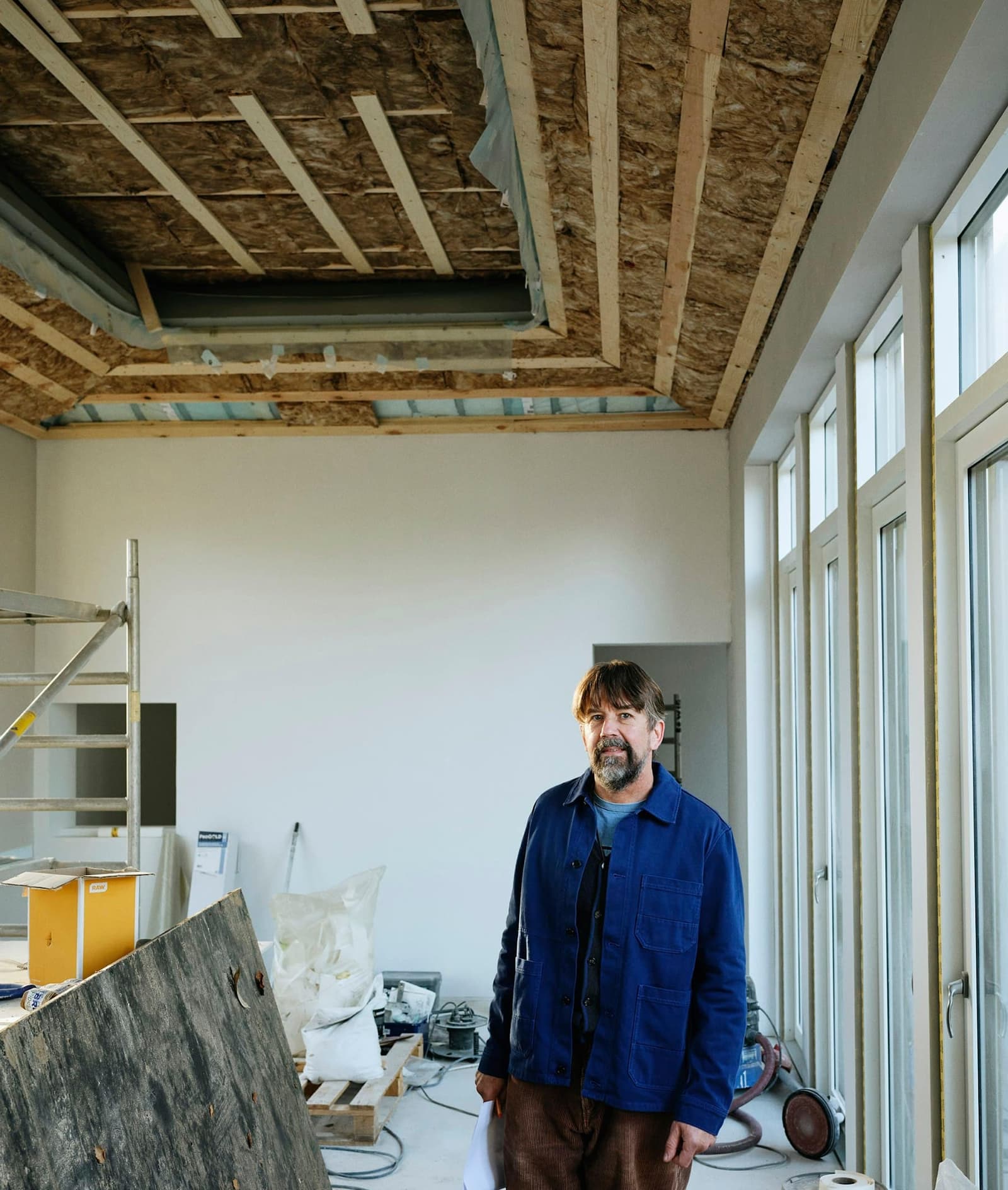 Portrait placeholder: a contractor standing in a bright room under renovation